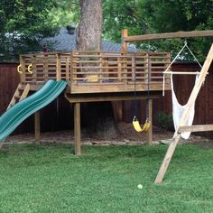 a wooden swing set and slide in the backyard