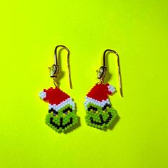 the grin face earrings are made out of plastic beads and have santa's hats on them