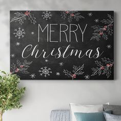 a christmas sign hanging on the wall above a couch