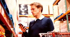 a man in a warehouse looking at his cell phone