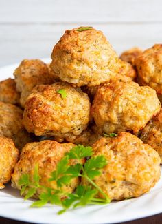 a white plate topped with meatballs and garnished with parsley on top