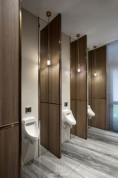 a bathroom with urinals and mirrors in it