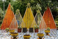 a table topped with lots of vases filled with flowers next to tall wooden poles