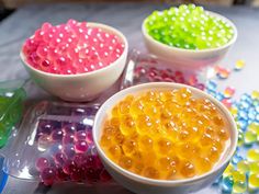 three bowls filled with jelly beans sitting on top of a table next to each other