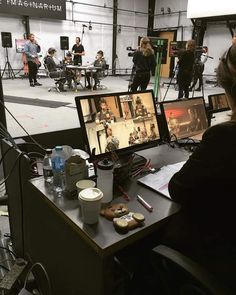 a woman sitting at a desk in front of a computer monitor with pictures on it