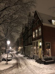 people walking down a snowy street at night