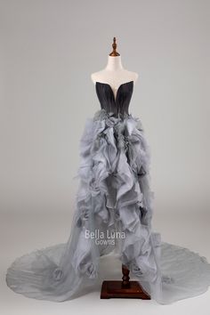 a dress on a mannequin with grey ruffles and black trimming