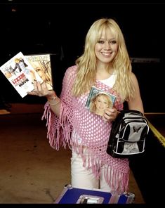 a woman holding up a magazine in her hand