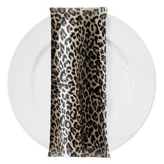 a white plate topped with a leopard print napkin