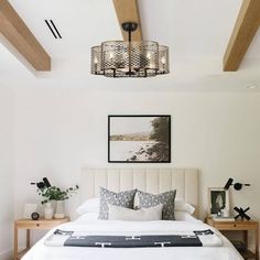 a bedroom with white walls and wood beams