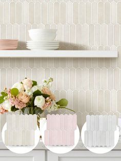 three vases with flowers in them sitting on a shelf next to some plates and bowls