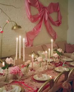 a dining room table set with plates and candles