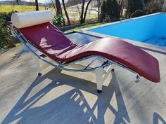 an empty chaise lounge next to a swimming pool