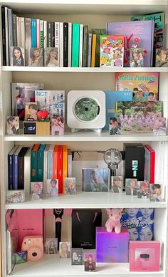 a white book shelf filled with lots of books and other items on top of it