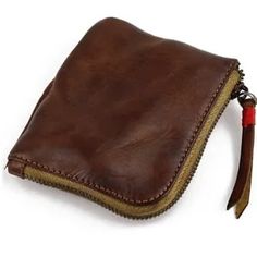 a brown leather pouch with a zipper on the side and a red cord attached to it