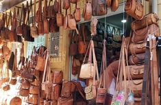 many purses are hanging up on the wall