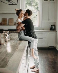 a man and woman are hugging in the kitchen