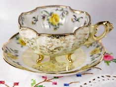 an antique tea cup and saucer on a table