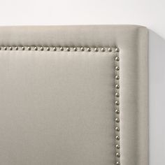 an upholstered headboard with studded trim and buttons on the back of it