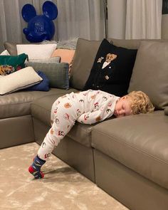 a little boy that is laying down on a couch