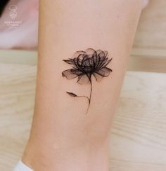 a black flower tattoo on the right side of the leg and it's petals