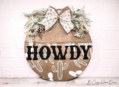 a wooden sign with the word hodgy up painted on it and a bow