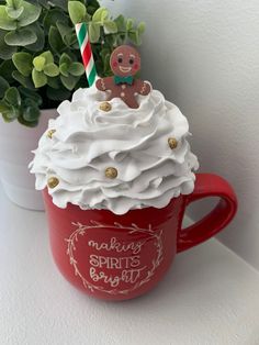 a red cup filled with whipped cream and a gingerbread man on top of it