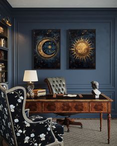 an office with blue walls and two paintings on the wall