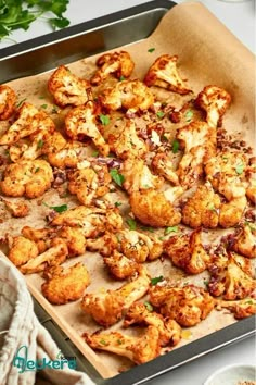 roasted cauliflower on a baking sheet ready to go into the oven with parsley