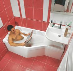 a man sitting in a bathtub reading a magazine