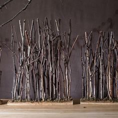 three wooden planters sitting next to each other on top of a wood floor covered in branches