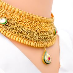 This magnificent choker set, crafted from 22k gold with an antique finish, weighs 69.1 grams. It showcases opulent paisley motifs accented with Kundan stones. The necklace is 14.5 inches long and 1.5 inches wide, featuring a drop length of 0.9 inches, creating a statement of refined elegance. With 1 inch of adjustable links, it ensures a perfect fit, secured by a hook lock. The set includes matching earrings, each 3 inches in length, equipped with screw-back posts for secure wear. This ensemble 22k Gold Kundan Necklace For Diwali And Formal Occasions, Heavy Gold Kundan Necklace For Formal Occasions, Formal Heavy Yellow Gold Kundan Necklace, Traditional Festive Choker For Formal Occasions, Traditional Formal Choker For Festivals, Traditional Festive Formal Choker, Formal Traditional Choker, Formal Festive Traditional Choker, Gold Temple Necklace With Intricate Choker Design