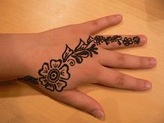 a woman's hand with a henna tattoo on it