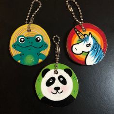 three key chains with animals on them sitting next to each other in front of a black table