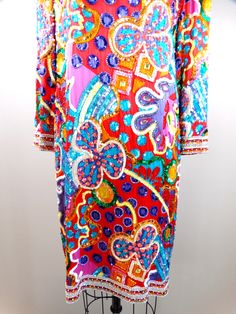 "This is a psychedelic vintage piece from Black Tie Oleg Cassini. It's fully embellished and hand beaded with colorful sequins and beads. It's in perfect condition! Size - US 10 Bust - 40\" Waist - 40\" Hips - 40\" Length - 38\" This dress comes from a pet-free and smoke-free home. If you would like more info or have any questions, please don't hesitate to ask!" Long Sleeve Sequin Dresses For Festivals, Bohemian Party Dress With Colorful Pattern, Festive Multicolor Embroidered Sequin Dress, Festive Multicolor Embroidery Sequin Dress, Bohemian Red Sequin Dress, Multicolor Long Sleeve Dress With Mirror Work, Festive Multicolor Hand Embellished Dress, Festive Multicolor Hand-embellished Dress, Multicolor Embellished Bohemian Dress