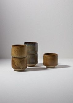 three wooden bowls sitting next to each other on a white counter top in front of a wall