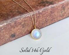 Rainbow Moonstone Necklace, Solid 14k Gold Pendant, June Birthstone, Real Gold Moonstone Jewelry , Birthday gift for her, Mother's Day Gift This classic minimalist necklace features a stunningly perfect flashy rainbow moonstone round puffy pendant bezeled in solid 14k gold. The blue flash moonstone pendant is suspended from a dainty solid 14k gold cable chain that come with 3 built-in adjustments to take this necklace to 16, 17 or 18 inches, whenever you needed.  Some pictures are magnified to show details, please read full description for accurate measurements, as well as all pictures on the model and the video provided. All elements of this necklace are 100% SOLID Gold. They will never tarnish or give an allergic reaction.  About this Necklace:  - Gemstone: Rainbow Moonstone - Birthstone Gold Moonstone Necklaces For Anniversary, Gold Moonstone Necklace For Anniversary, Moonstone Round Necklace For Gifts, Moonstone Birthstone Necklace Gift, Handmade Round Birthstone Necklace For Anniversary, White Round Jewelry For Birthday Gift, White Jewelry For Birthday Gift, Moonstone Round Necklace For Anniversary, White Gemstone Birthstone Necklace Gift