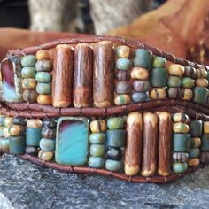 aqua double wrap bracelet by offbeadinpathneosho  Matte, antiqued Czech beads in vibrant hues of aqua, turquoise, picasso and cremes are paired with coconut wood tubes in this double wrap leather bracelet. aqua, turquoise, and buruandy Czech glass are splashed in between it all for more fun. the leather is a distressed and supple shade of chocolate, soft and warm. The button is straight from Shanghai...a rustic little matte pewter gem splashed with turquoise. Artisan Turquoise Hand Wrapped Wrap Bracelet, Artisan Hand Wrapped Turquoise Wrap Bracelet, Artisan Turquoise Wrap Bracelet For Festivals, Coconut Wood, Double Wrap Bracelet, Turquoise Glass, Aqua Turquoise, Coconut Shell, Tube Beads