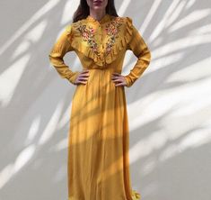 Gorgeous 70s style maxi dress in pumpkin yellow color . Features ruffled neckline with buttons, covered in the same fabric , flowers embroidery , long sleeves and elasticated hight waist . Doesn't have a zipper , it is pull on dress. This item is in style of the 70s but it is 00s item . Material tag is missing , but it is viscose - very soft . Labeled as size S / M would fit both sizes . Length - approx 158 cm , chest - 94 cm , width waist - 60 cm to 88 cm maximum . Vey good vintage condition Yellow Long Sleeve Maxi Dress With Ruffles, Yellow Ruffled Long Sleeve Maxi Dress, Yellow Long Sleeve Ruffled Maxi Dress, Yellow Bohemian Maxi Dress For Fall, Bohemian Orange Maxi Dress With Ruffles, Spring Embroidered Yellow Maxi Dress, Yellow Maxi Dress With Floral Embroidery, Spring Yellow Embroidered Maxi Dress, Mustard Bohemian Maxi Dress