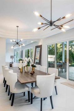 a dining room table with white chairs around it