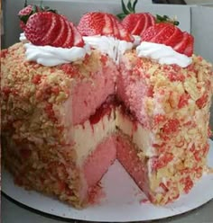 a cake with strawberries and cream on top is cut in half to show the layers