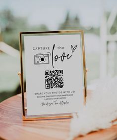 a wooden table topped with a sign and a white feather on top of the table