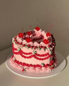 a pink and red cake sitting on top of a white plate