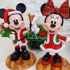 two mickey mouse figurines dressed in christmas attire