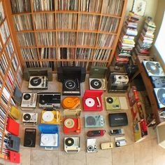 an aerial view of various records and audio equipment in a room full of bookshelves