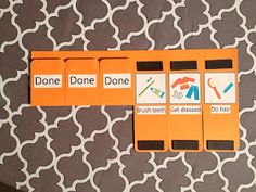 three orange boxes with different words on them sitting on top of a patterned table cloth