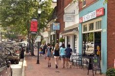 people walking down the sidewalk in front of shops