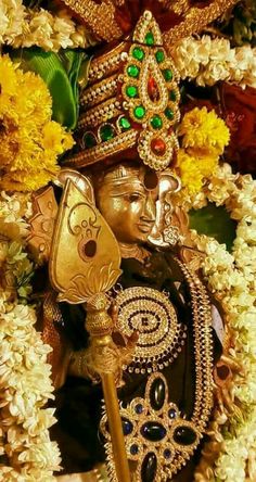 an idol is surrounded by flowers and other decorations