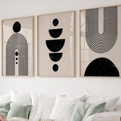 three black and white art prints hanging on the wall above a couch in a living room