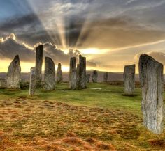 the sun is shining through the clouds over stonehenge circle in england, uk